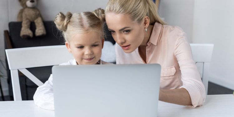 Mutter lernt mit Kind am Laptop