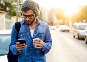 Junger Mann mit Smartphone - IUBH Learn App