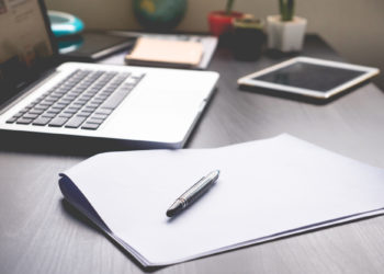 Arbeitsplatz, Schreibtisch mit Laptop und Notizen, Workbooks an der IU