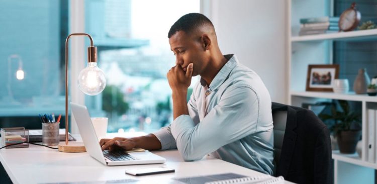 Mann sitzt am Schreibtisch im Home Office