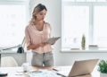 Junge Frau arbeitet am Schreibtisch, Selbstständigkeit nach dem Studium