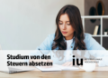 Studentin der IU sitzt am Schreibtisch und macht Steuern, IU Fernstudium Steuern absetzen