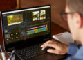 Freelancer video editor works at the laptop computer with movie editing sofware. Videographer vlogger or blogger camera man at work editing vlog.