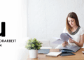 Studentin an der IU sitzt am Schreibtisch, Abgabe der Bachelorarbeit