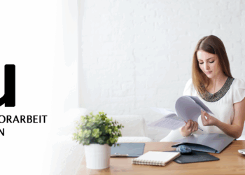 Studentin an der IU sitzt am Schreibtisch, Abgabe der Bachelorarbeit