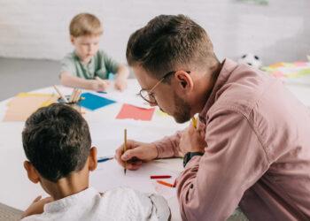 Lehrer am Tisch mit Schülern